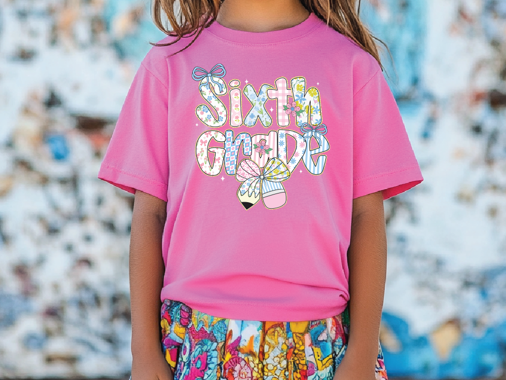 a little girl wearing a pink shirt with the words sixth grade on it