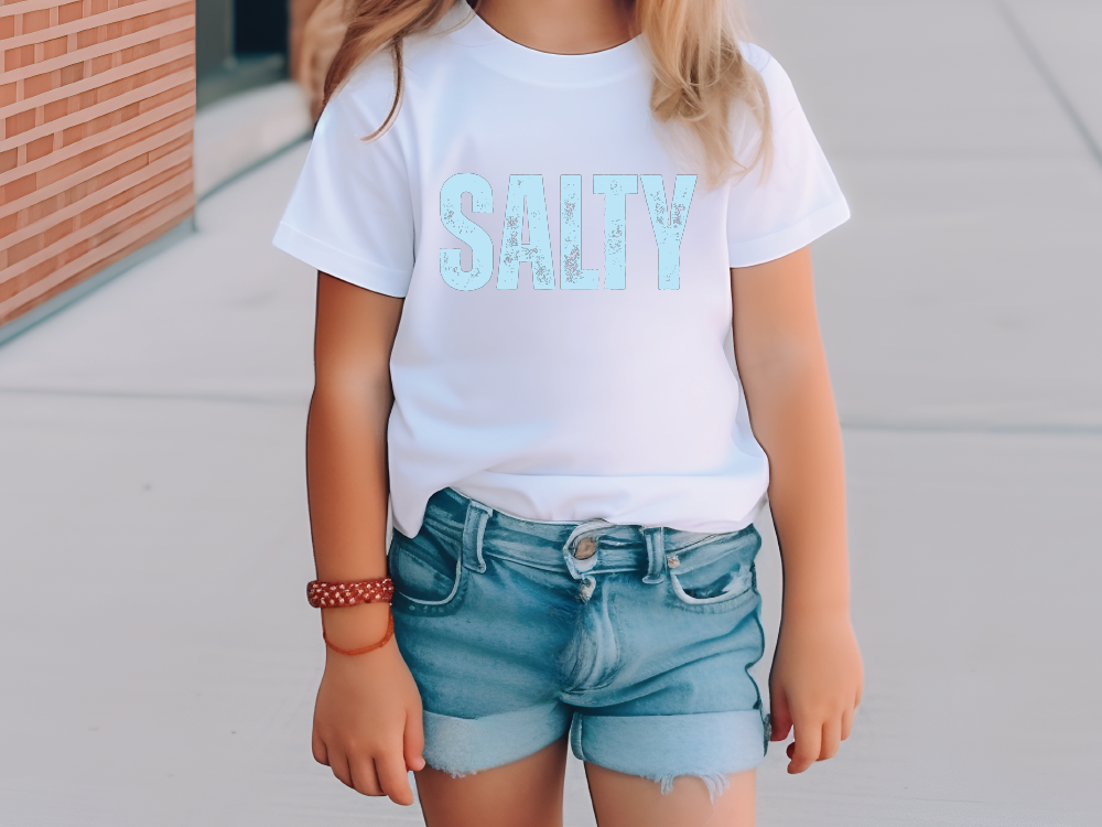 a little girl wearing a t - shirt that says salty