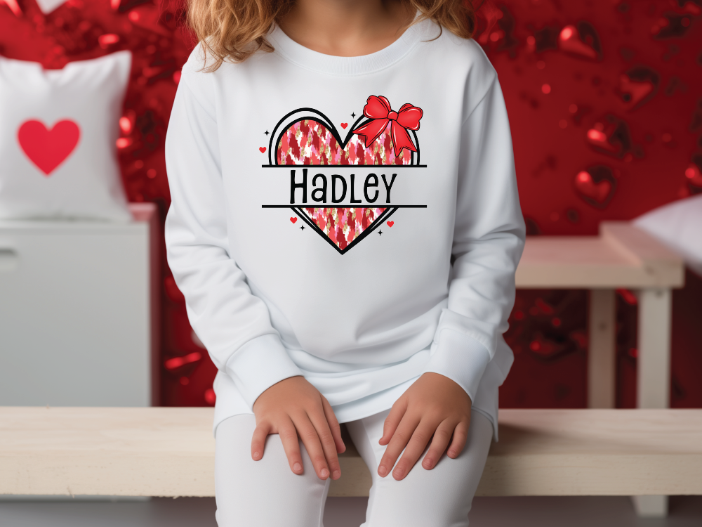 a little girl sitting on a bench wearing a sweatshirt