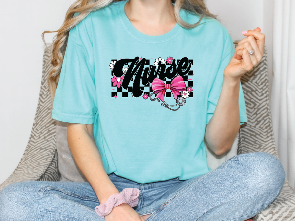 a woman sitting on a couch wearing a turquoise shirt with a pink bow