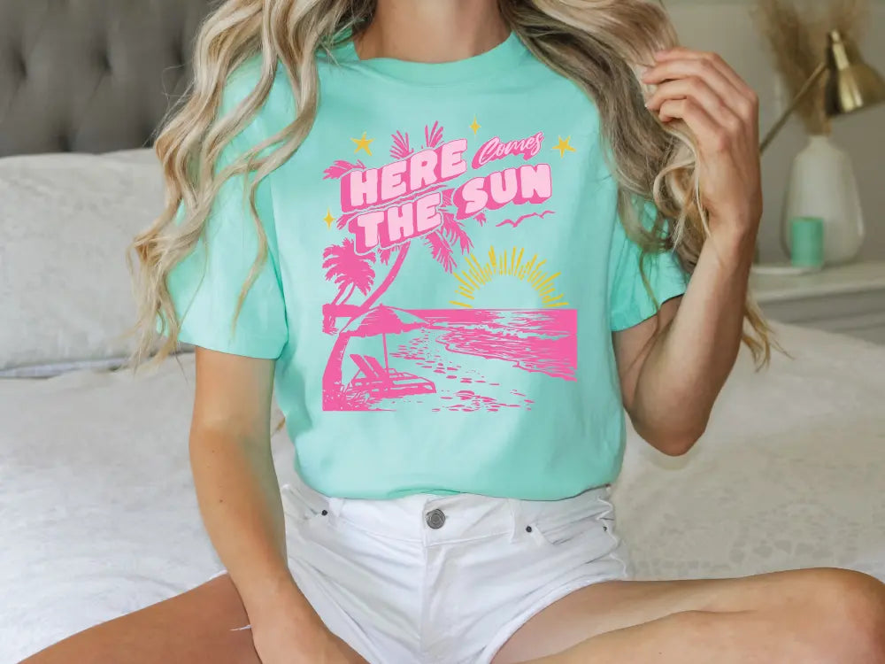 a woman sitting on a bed wearing a t - shirt that says here is the