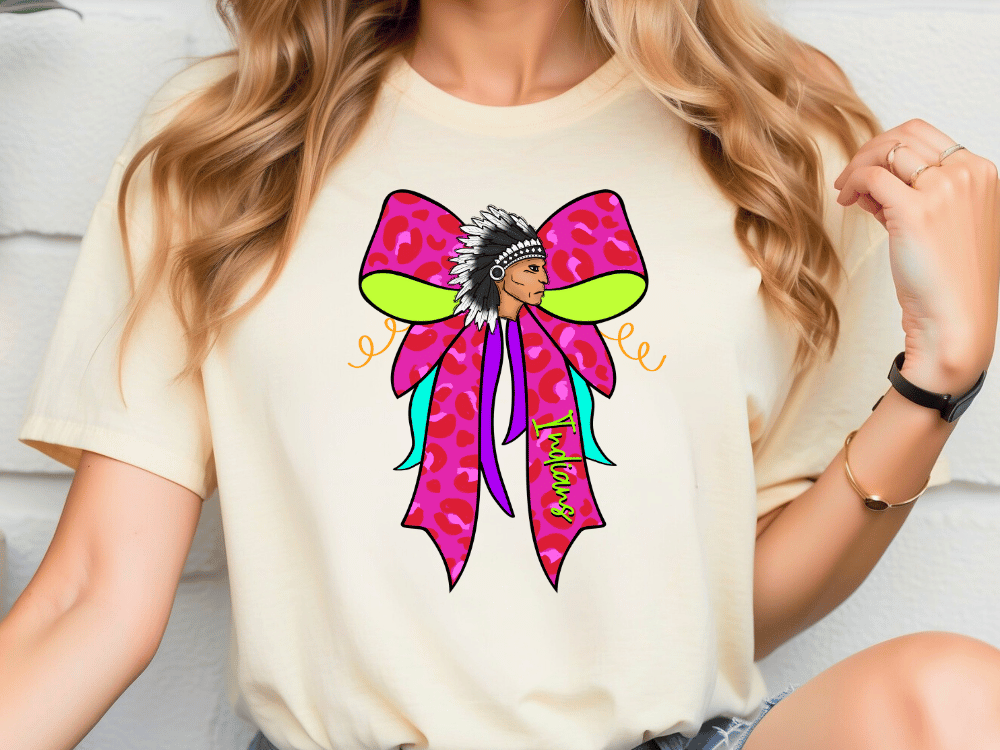 A woman wearing a white t-shirt with a colorful graphic design featuring a stylized Native American headdress.