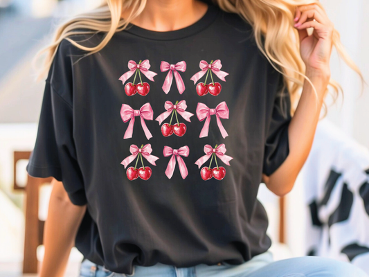 a woman wearing a black shirt with pink bows and cherries on it