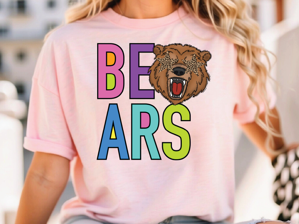 A woman wearing a pink t-shirt with the word "BEARS" printed on it, along with a cartoon bear's head.