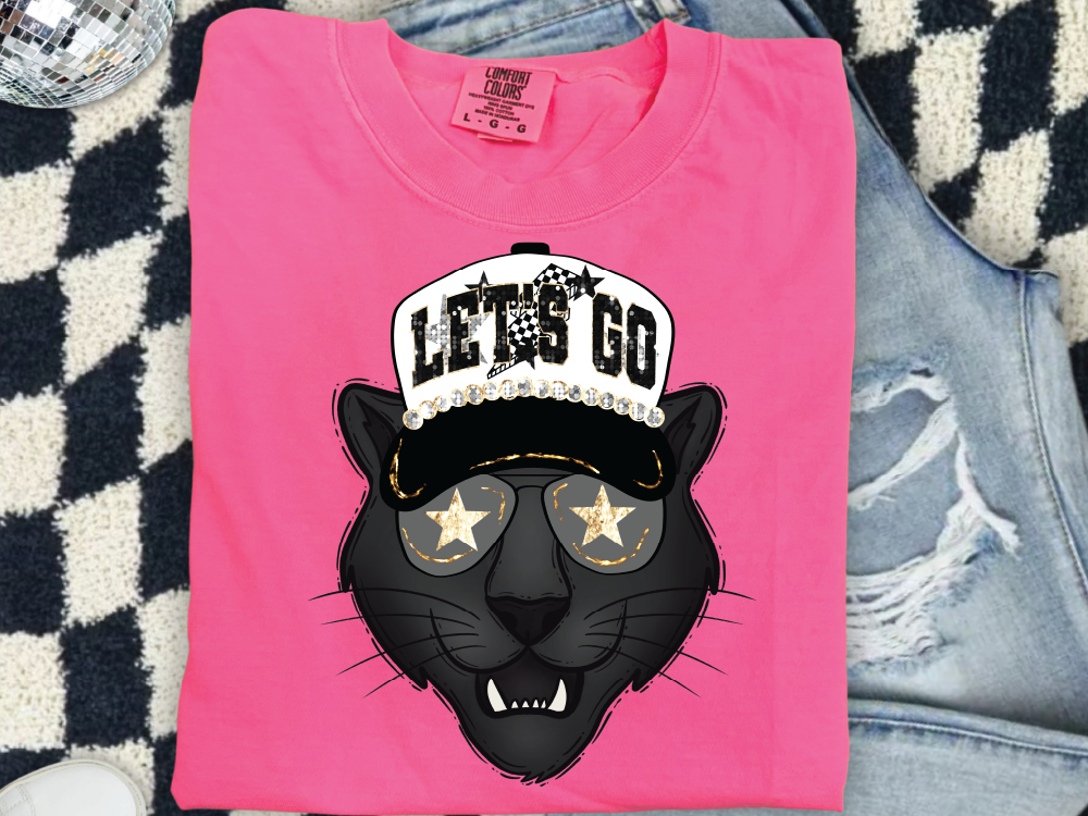 A pink t-shirt with a graphic design of a black panther wearing a baseball cap and sunglasses, along with the text "LET'S GO".