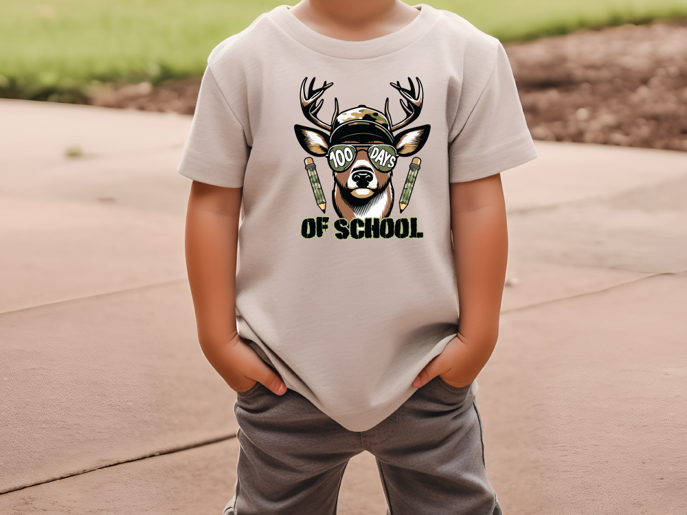 a young boy wearing a t - shirt with a deer on it