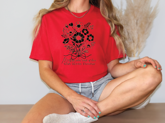 a woman sitting on a table wearing a red shirt