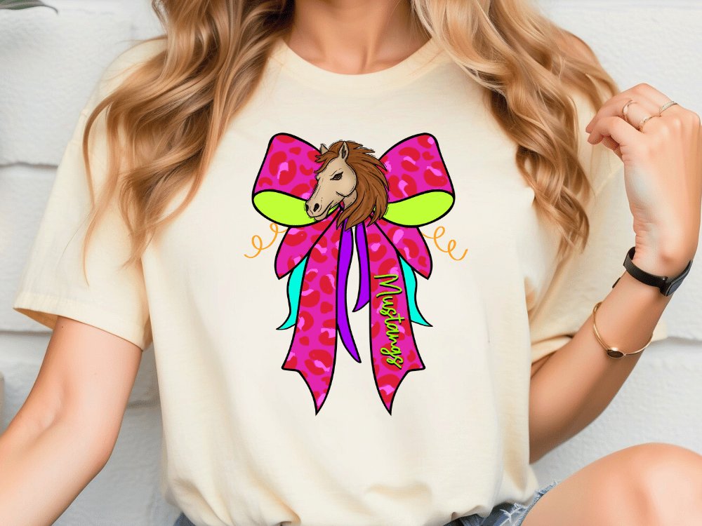 A woman wearing a white t-shirt with a colorful graphic design of a horse's head wearing a pink bow.