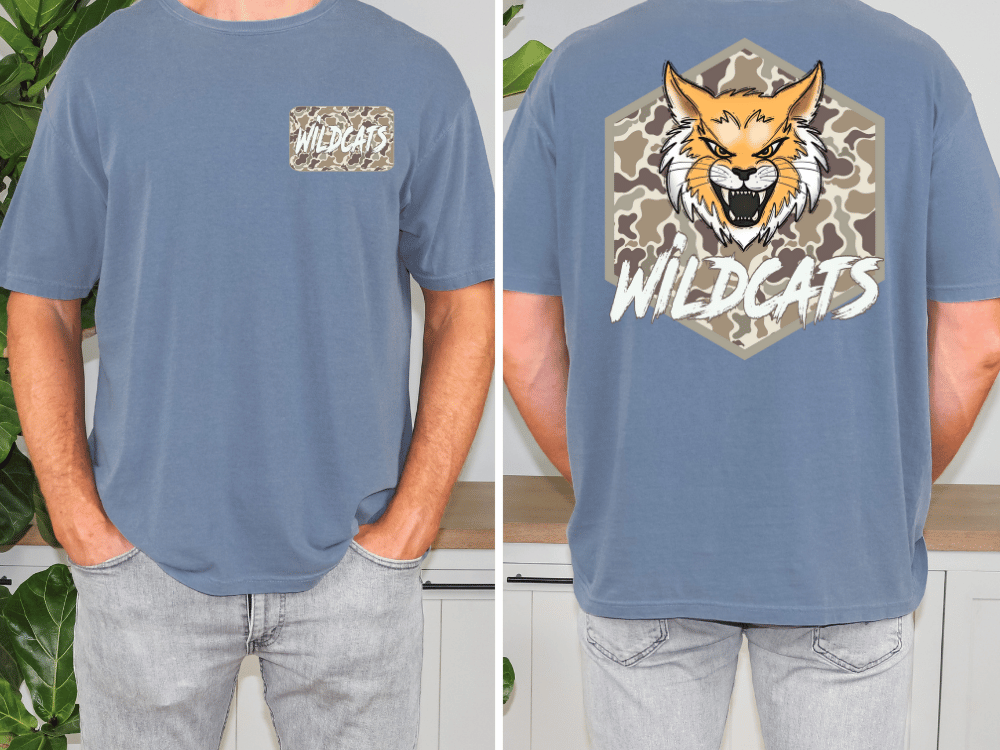 a man wearing a blue t-shirt with a graphic design featuring a cartoon-like wildcat and the word "WILDCATS" printed on it.