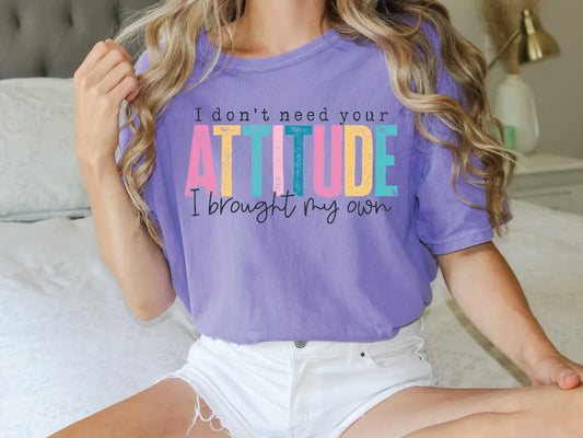 a woman sitting on a bed wearing a shirt that says i don't need