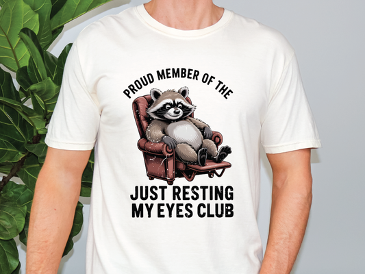 a man wearing a white shirt with a raccoon on it