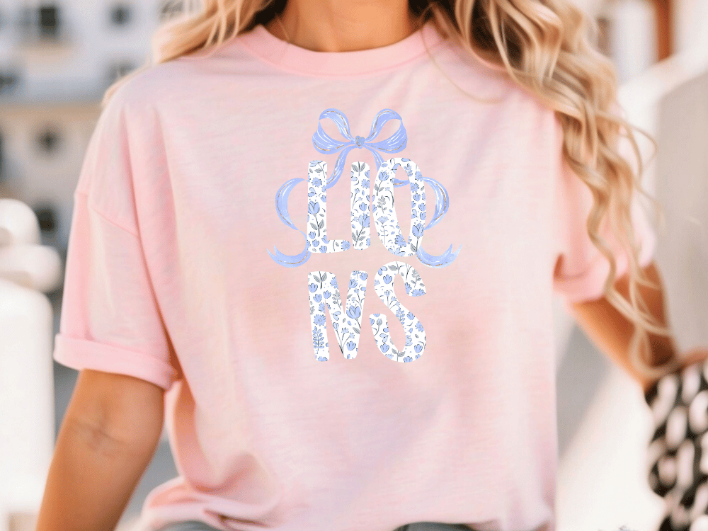 A woman wearing a pink t-shirt with the text "LESS THAN 500" printed on it.