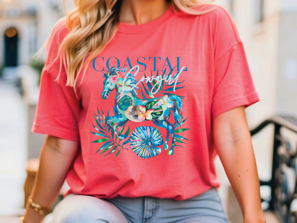 A woman wearing a red t-shirt with a colorful graphic design of a horse and tropical leaves.