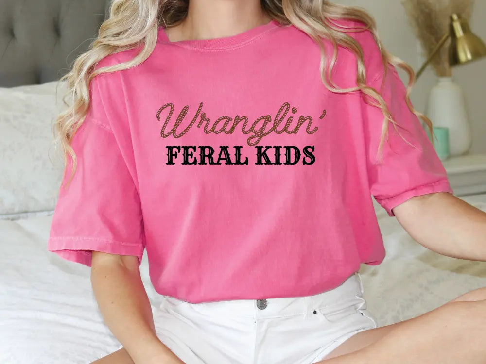 a woman sitting on a bed wearing a pink shirt
