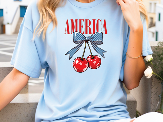 a woman wearing a blue shirt with two cherries on it