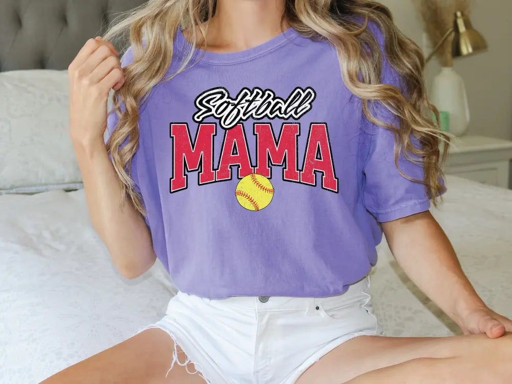 a woman sitting on top of a bed wearing a purple shirt