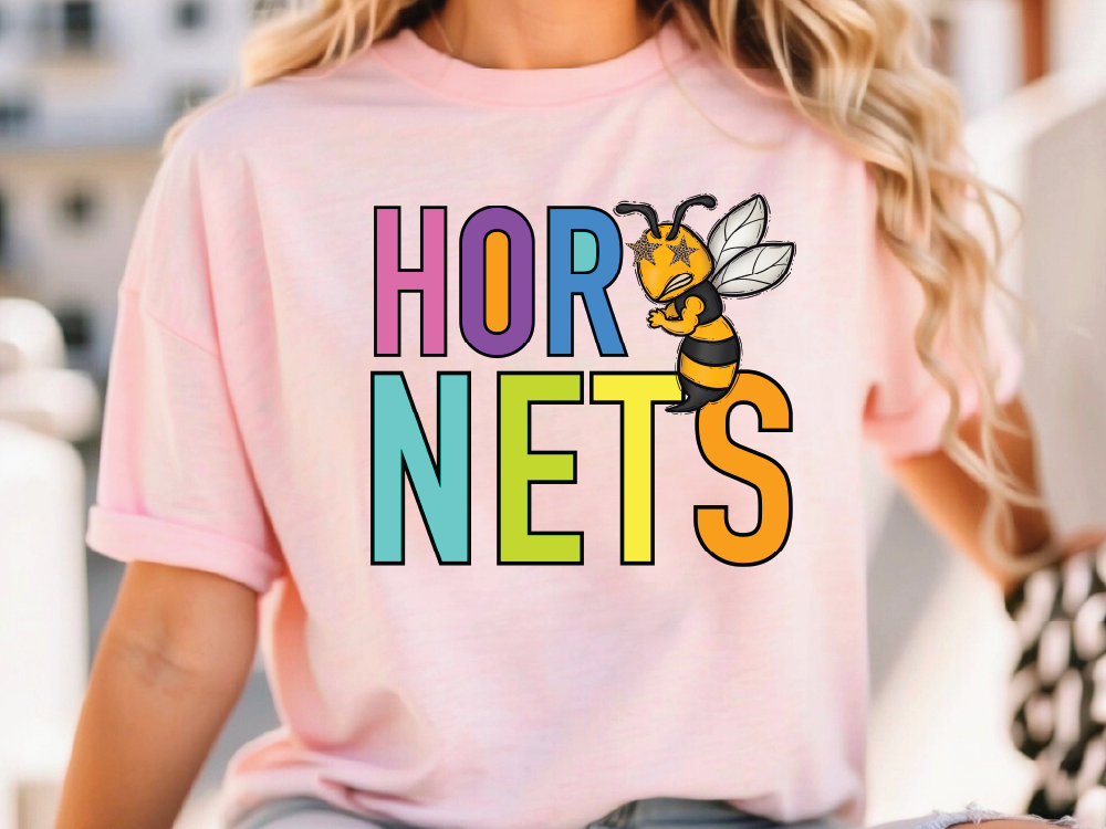 A woman wearing a pink t-shirt with the text "HOR NETS" printed on it, featuring a cartoon bee character.