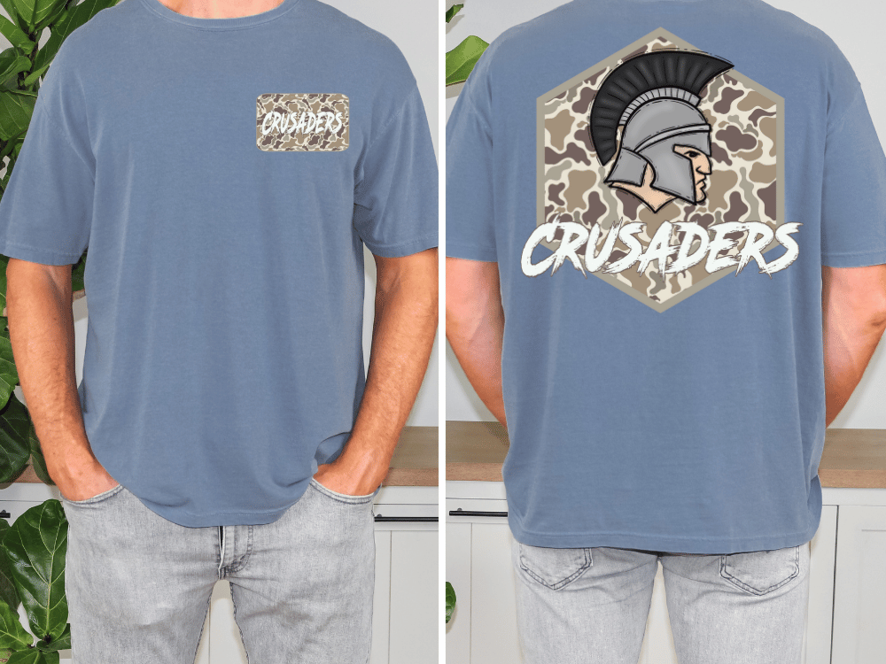 a man wearing a blue t-shirt with a graphic design on the back. The design features a helmet with a plume and the word "CRUSADERS" written above it.