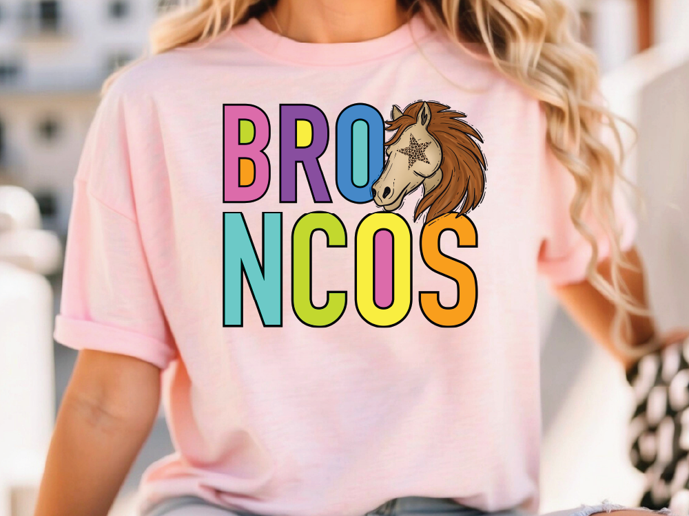 A woman wearing a pink t-shirt with the text "BRO N COS" printed on it.