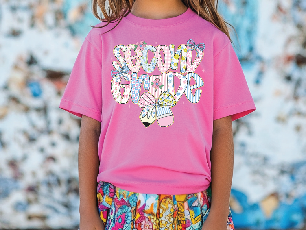 a little girl wearing a pink shirt and colorful shorts