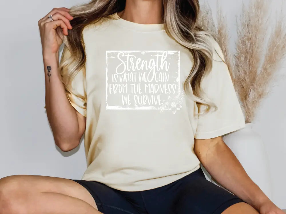 a woman sitting on a chair wearing a t - shirt