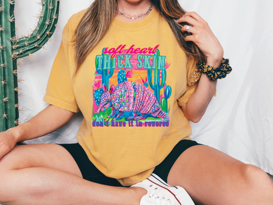 a woman sitting on the ground wearing a yellow shirt