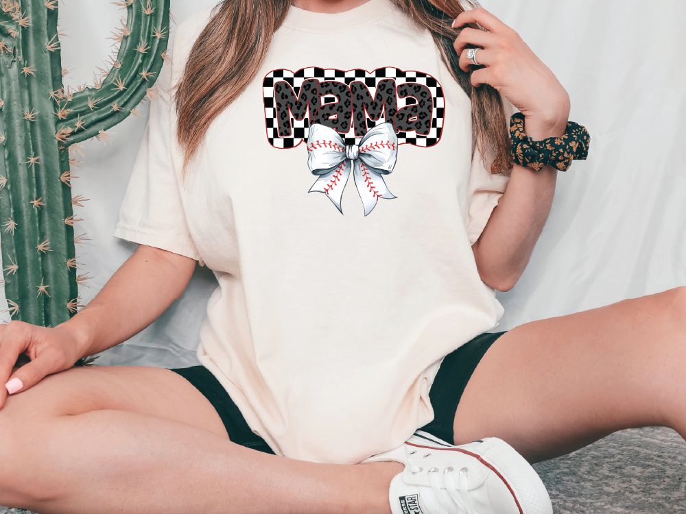 a woman sitting on the ground wearing a t - shirt with a bow on it