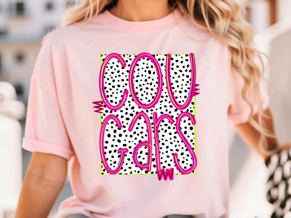 A woman wearing a pink t-shirt with the word "COUGARS" printed on it in a bold, pink font with black polka dots.