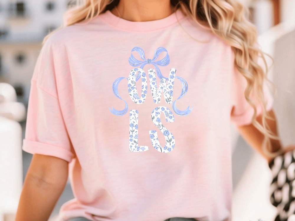 A woman wearing a pink t-shirt with the text "OWLS" printed on it.