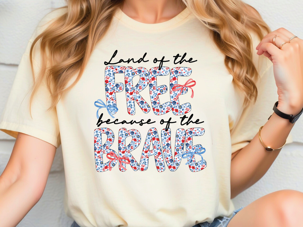 a woman wearing a t - shirt that says land of the free because of the