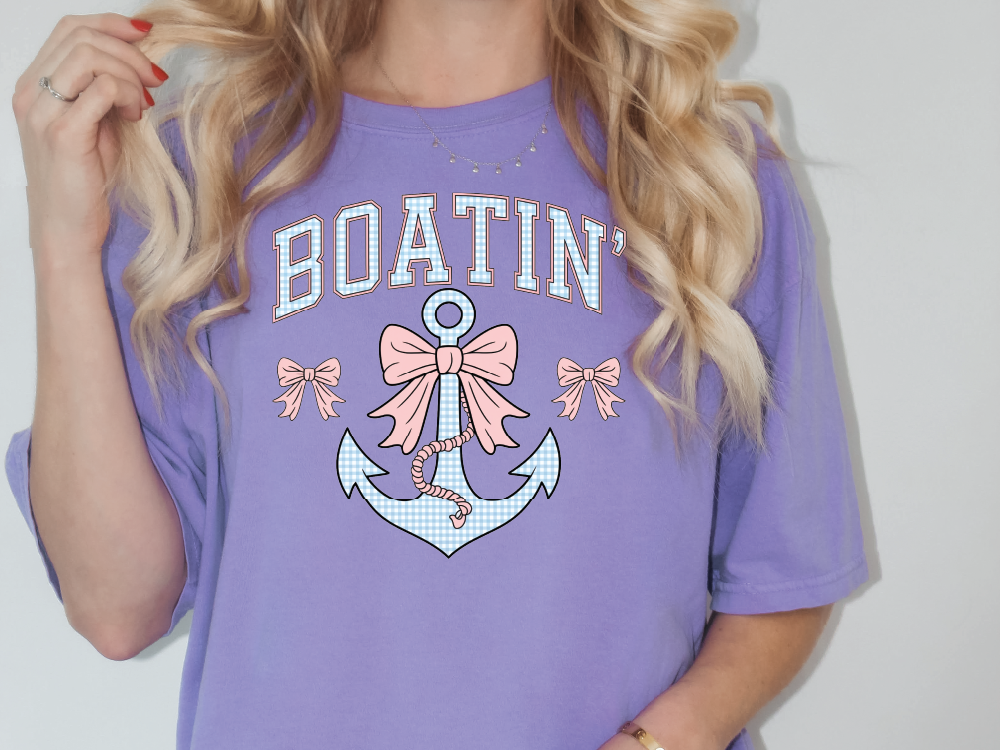 a woman wearing a purple boatin shirt with an anchor