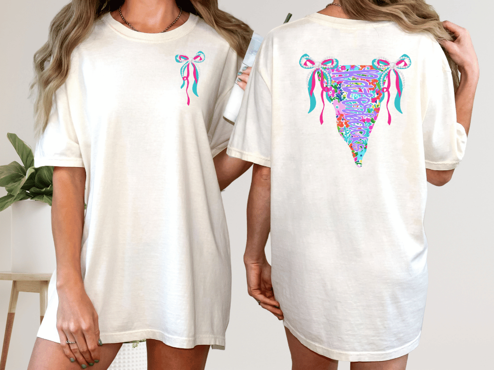 two women wearing white t-shirts with colorful floral designs on the back.