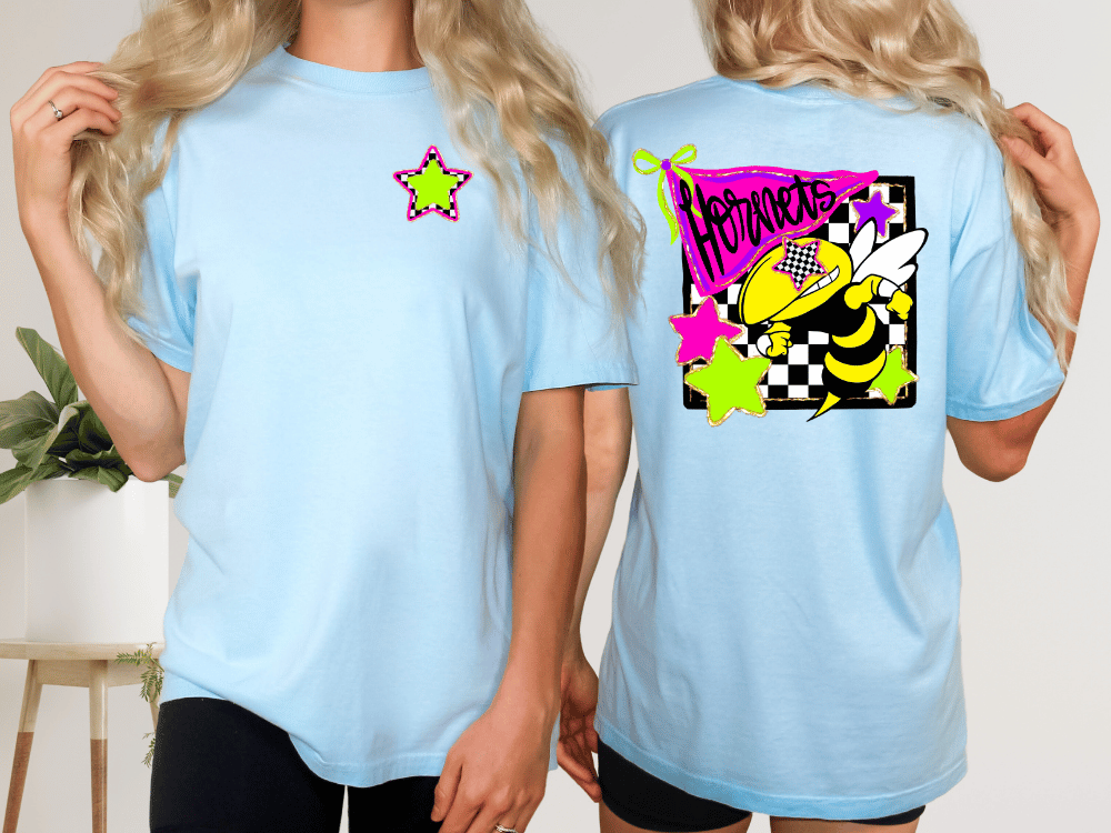 two women wearing light blue t-shirts with colorful designs on the back.