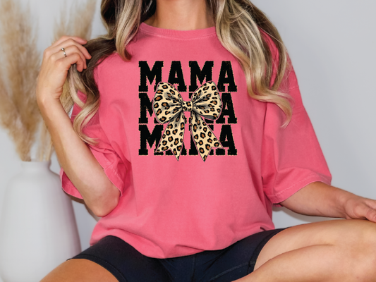 a woman wearing a pink shirt with a leopard print bow