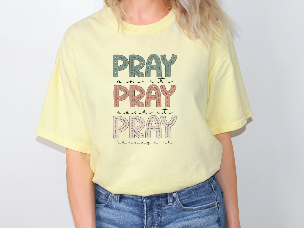 a woman wearing a yellow pray pray t - shirt