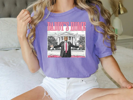 a woman sitting on a bed wearing a purple shirt and white shorts