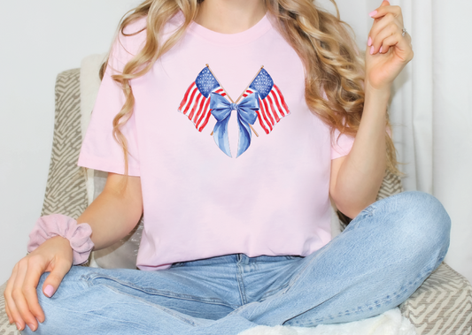 a woman sitting on a chair wearing a pink shirt with an american flag bow on