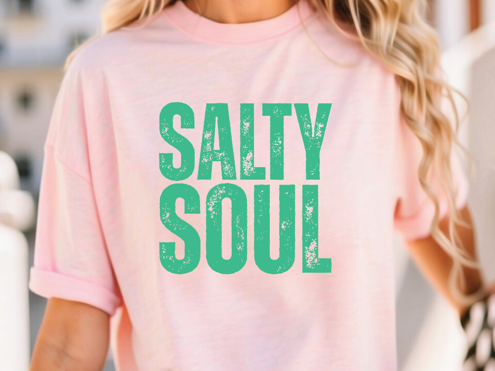 a woman wearing a pink shirt that says salty soul