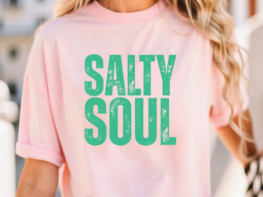 a woman wearing a pink shirt that says salty soul
