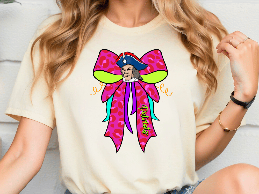 A woman wearing a white t-shirt with a colorful graphic design of a pirate's hat and bow on it.