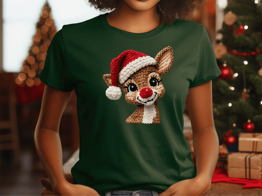 A woman wearing a green t-shirt with a Christmas-themed design of a smiling reindeer wearing a Santa hat.