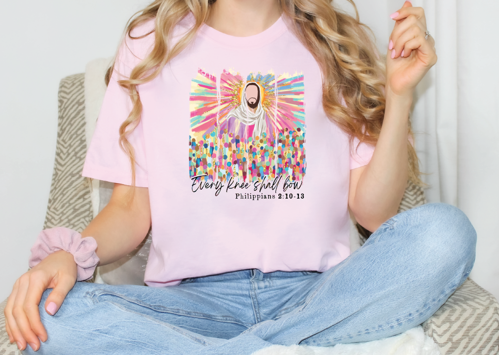 a woman sitting on a chair wearing a pink shirt