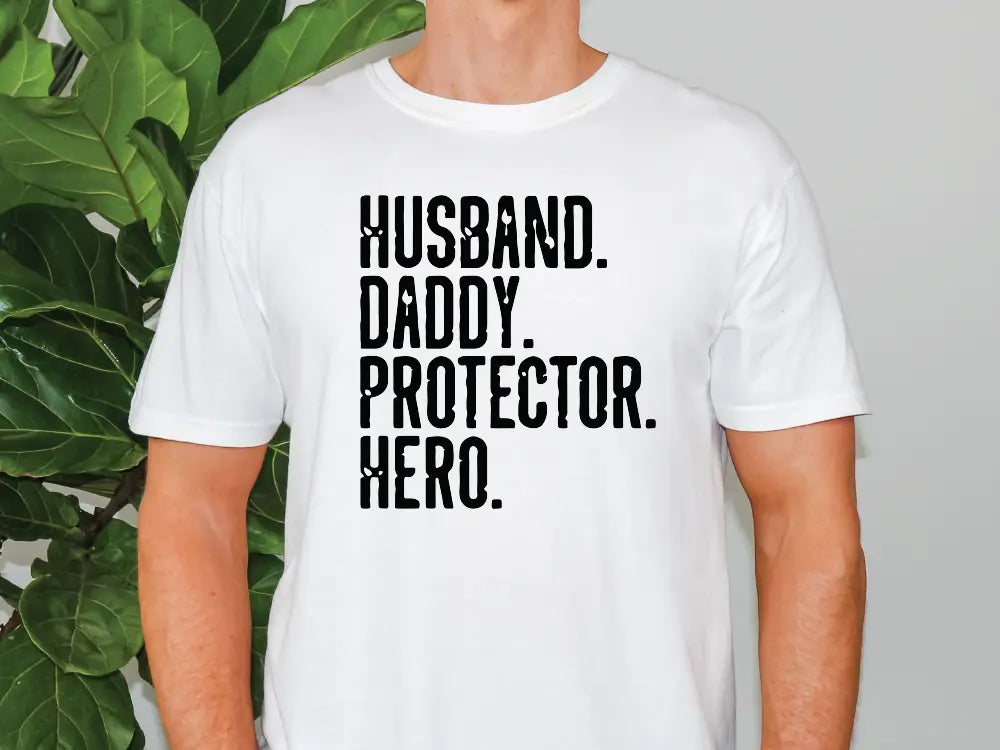 a man standing in front of a plant wearing a t - shirt that says husband