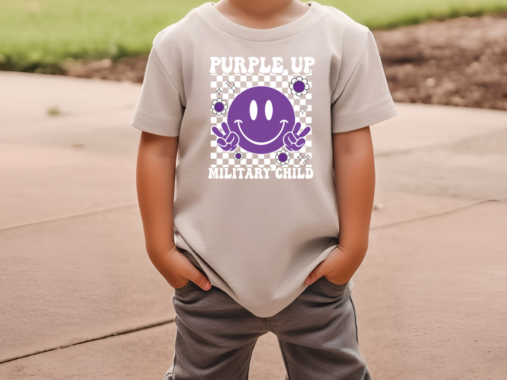 a little boy that is wearing a purple shirt