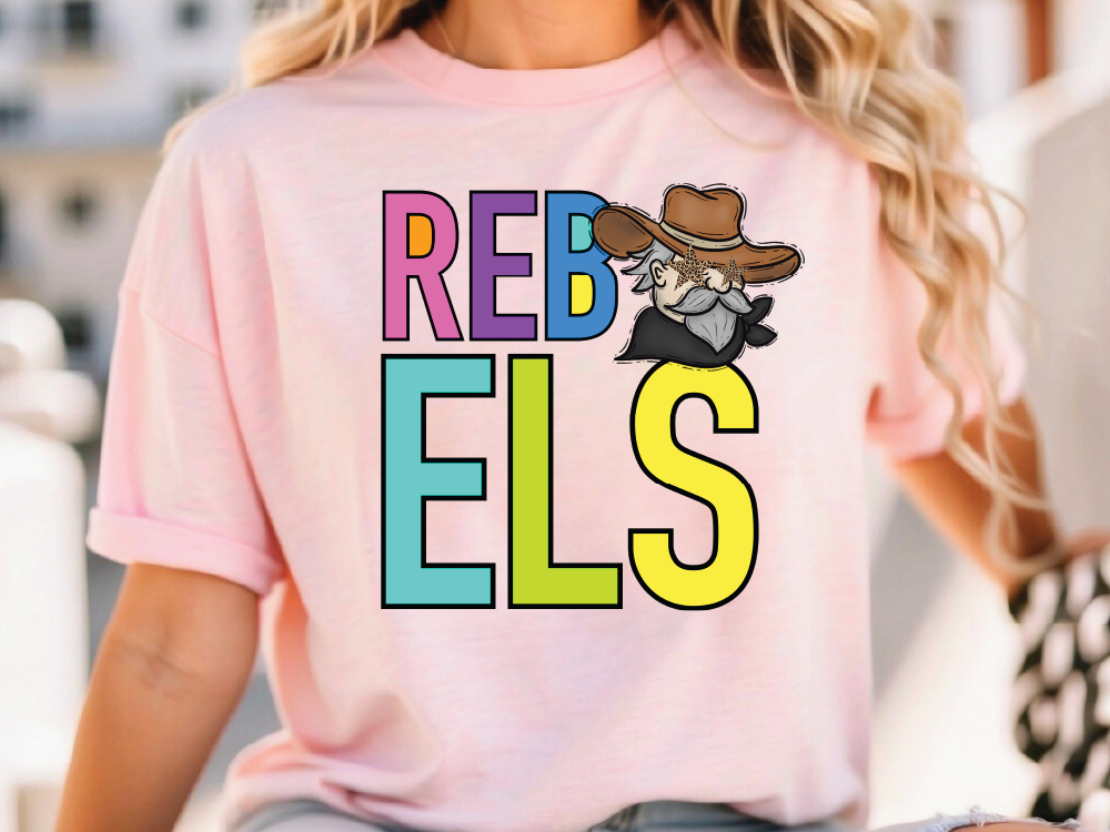 A woman wearing a pink t-shirt with the text "REBELS" and a cartoon character on it.