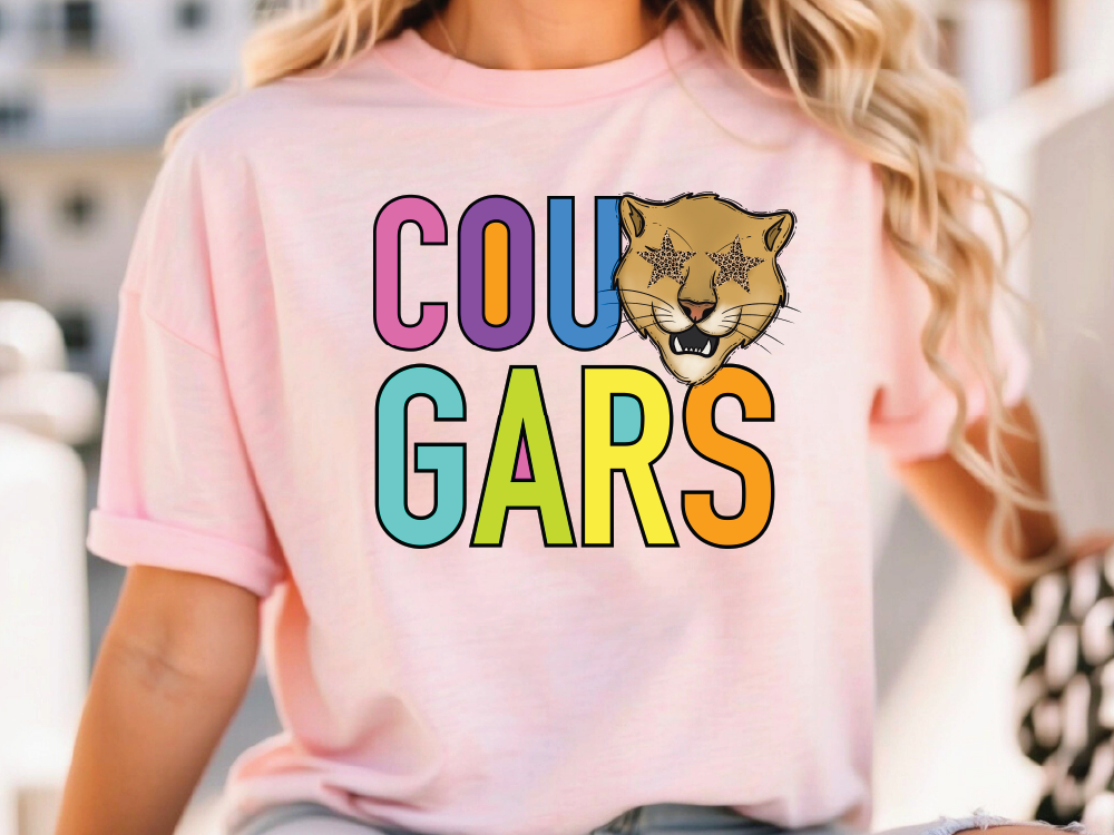 A woman wearing a pink t-shirt with the text "COU GARS" printed on it.