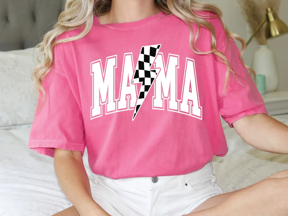 a woman sitting on a bed wearing a pink shirt