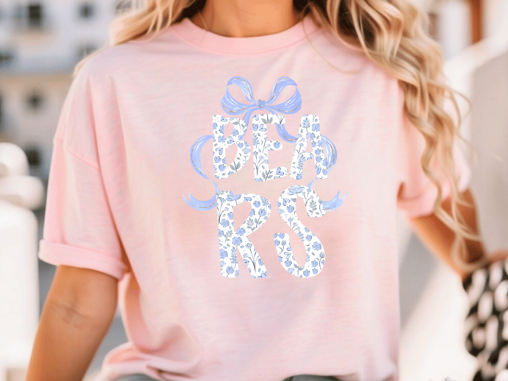 A woman wearing a pink t-shirt with the word "BEARS" printed on it.