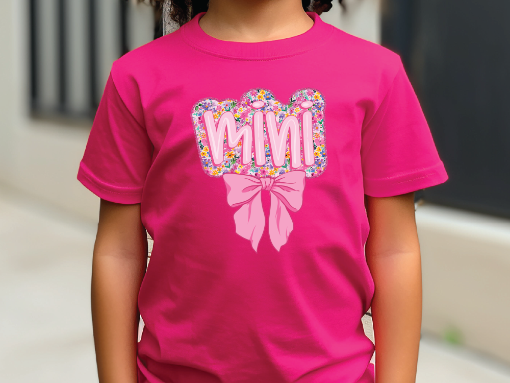 a little girl wearing a pink shirt with a bow