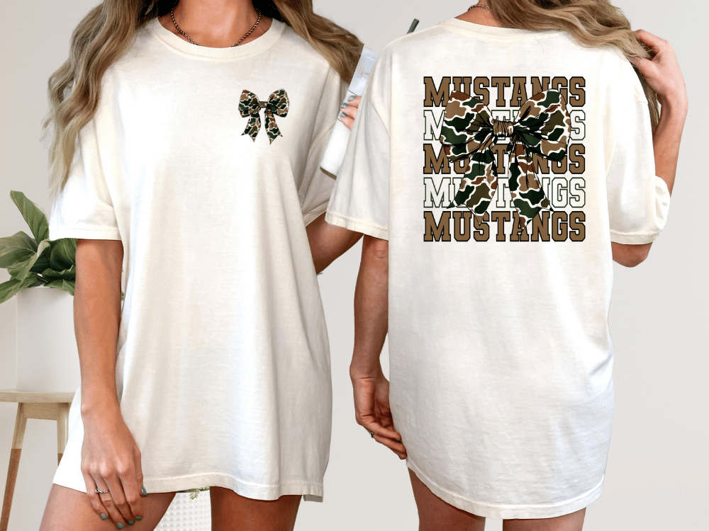 A woman wearing a white t-shirt with a bow and the word "Mustangs" printed on the back.